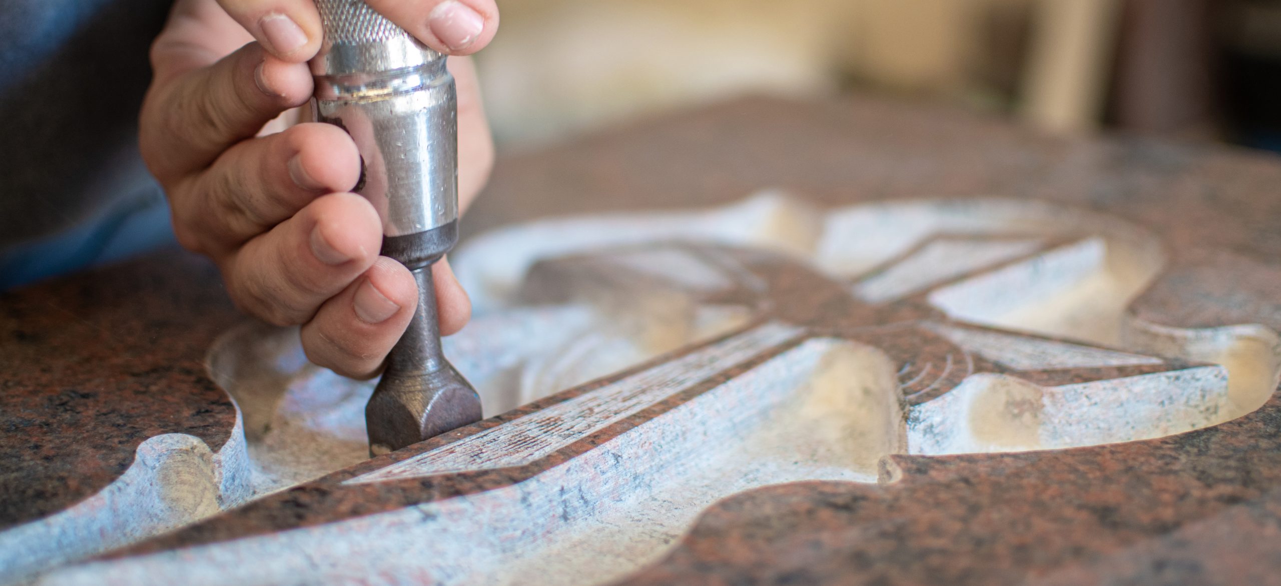 caucasian man hands bushhammered a tombstone in a workshop, work
